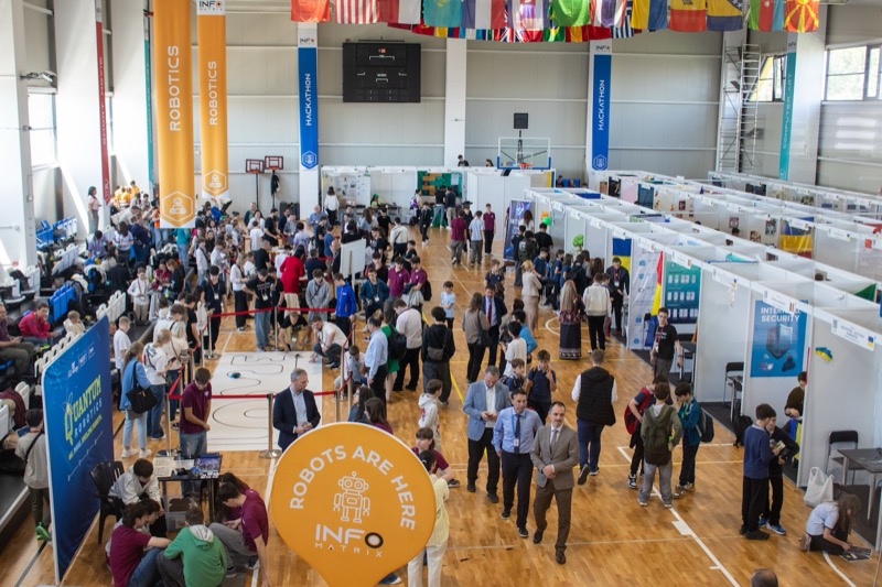 Infomatrix exhibition floor with robotics and hackathon booths